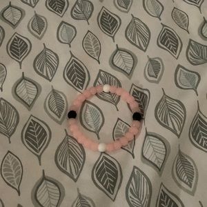 A pink and white and black bracelet